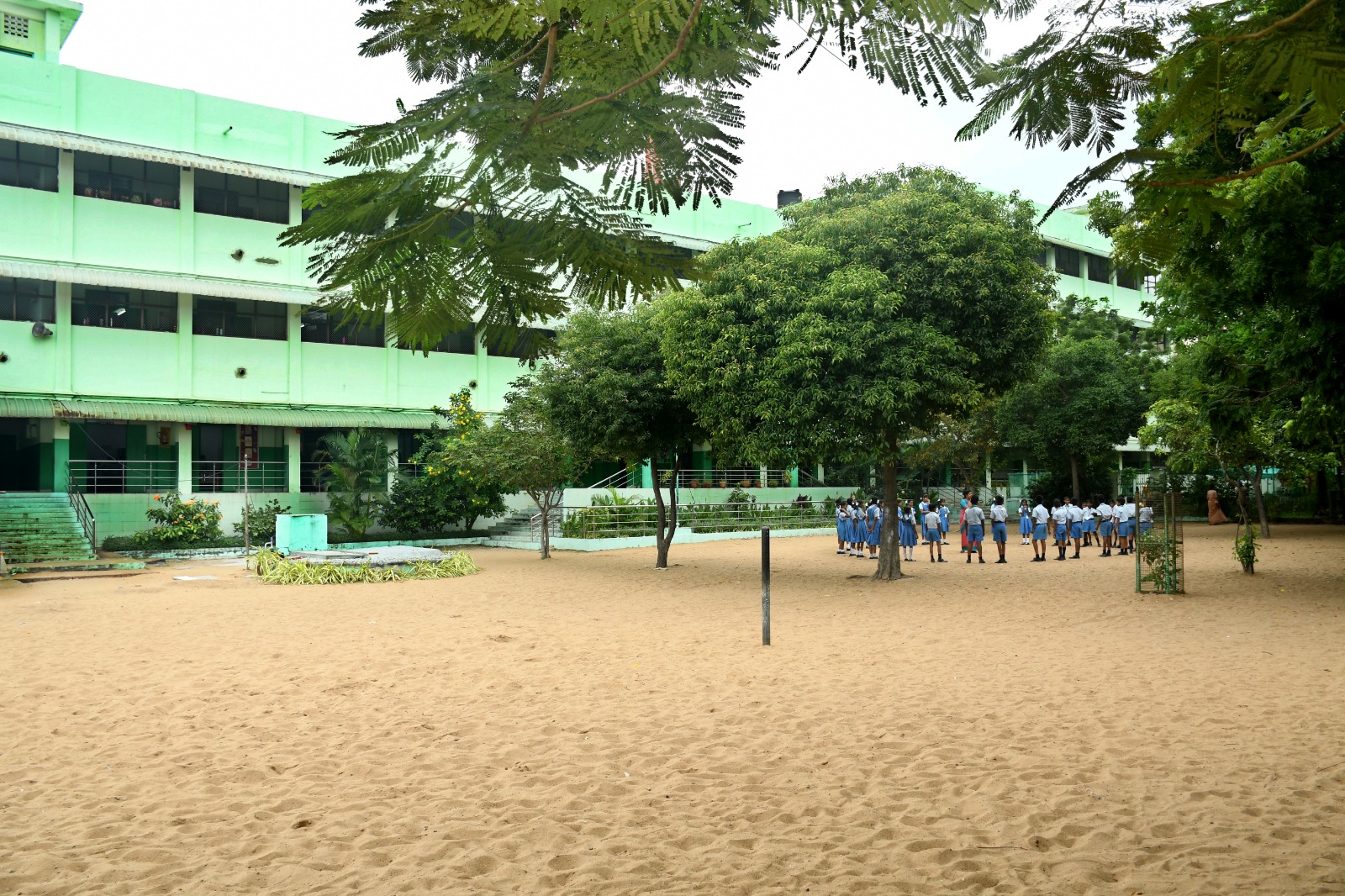 Large sand playground with trees